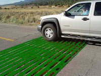 A truck crossing over a cattle grid.