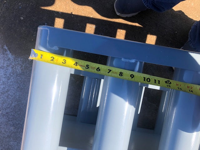 A tape measure on the round rails of a cattle guard.